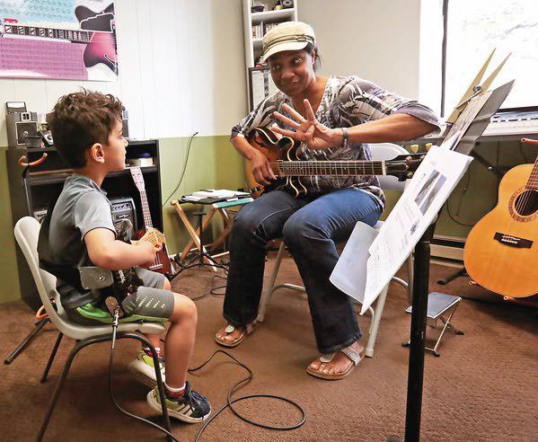 A young guitar student learns the basics of rock guitar